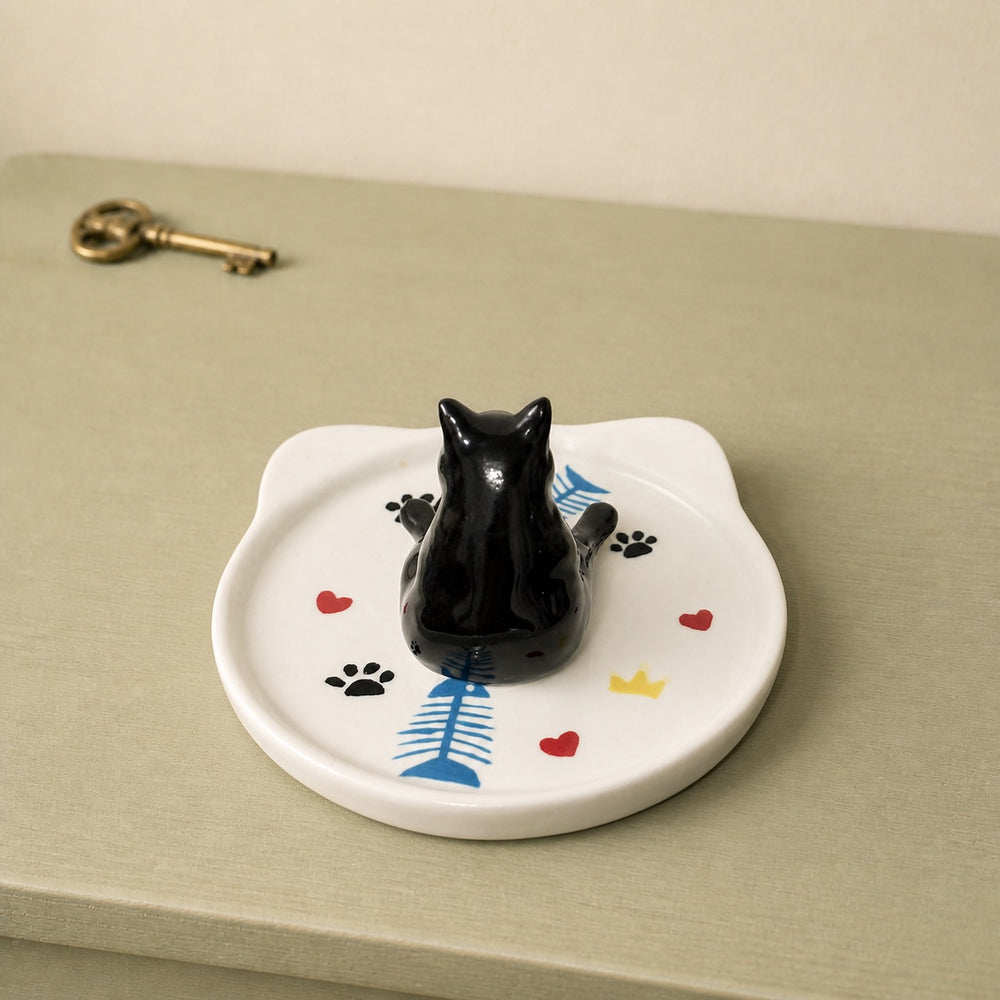 Black cat on a cat-face pet ring dish view 2