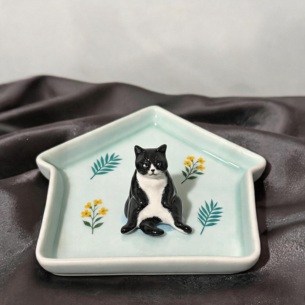 Teal cat on a house-shaped pet ring dish view 1