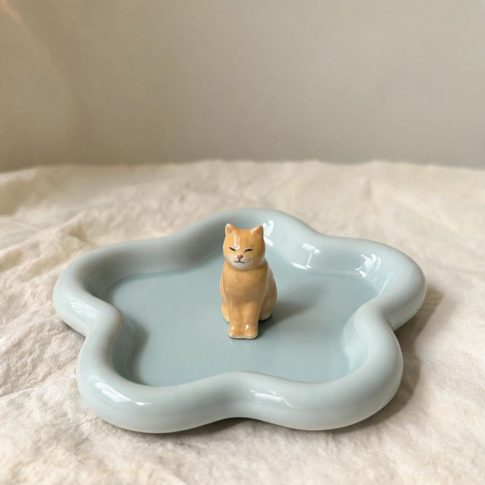 Teal cat on a star-shaped pet ring dish