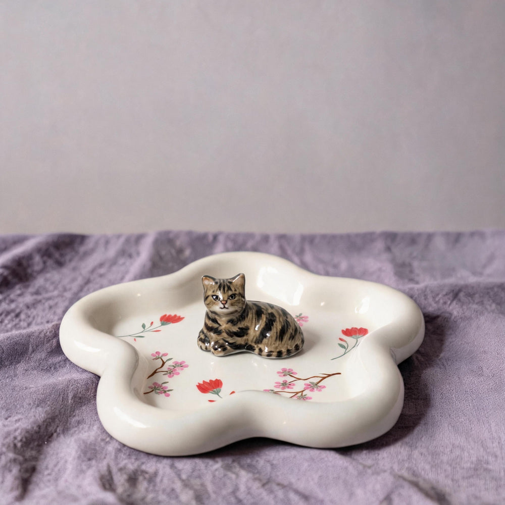 White cat on a star-shaped pet ring dish