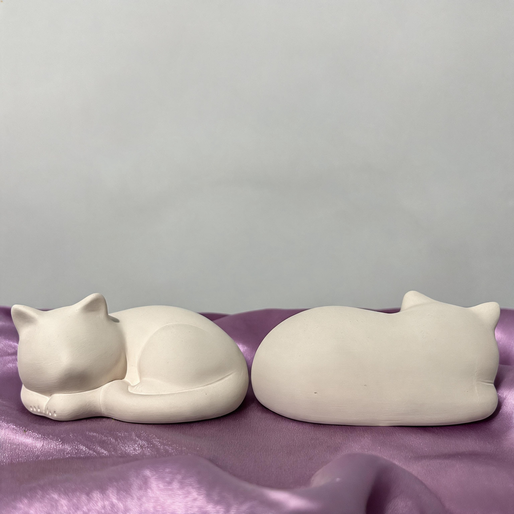 Unpainted sleeping cat figurine – front and back
