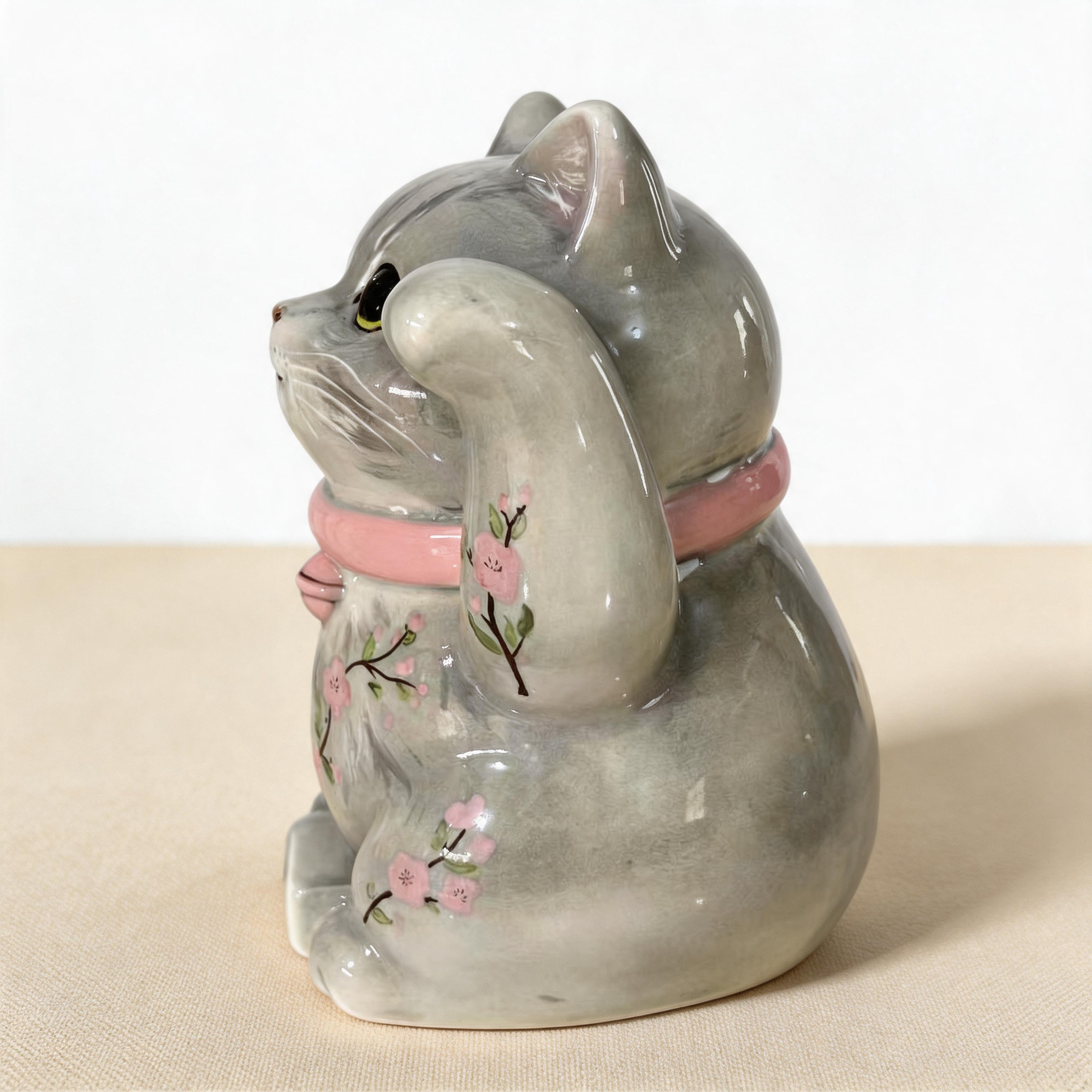 Close-up of the hand-painted detail of a personalized maneki neko lucky cat urn for ashes — a handmade ceramic cat memorial urn, hand-painted from your photos to match your cat and made to order. Custom pet memorial by Farbe Ceramics.