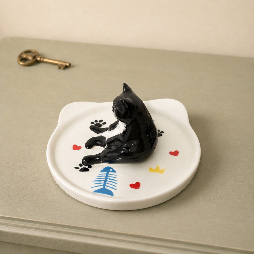 Black cat on a cat-face pet ring dish view 1