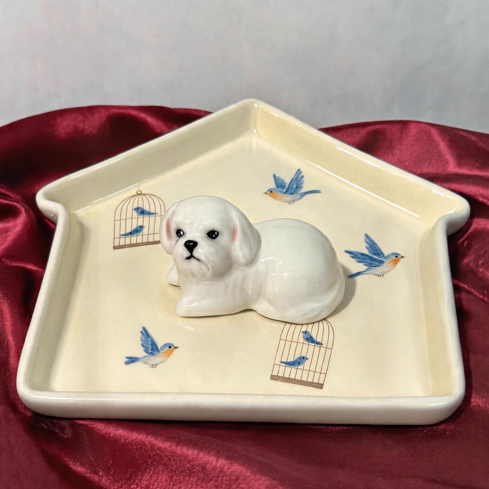 Yellow dog on a house-shaped pet ring dish