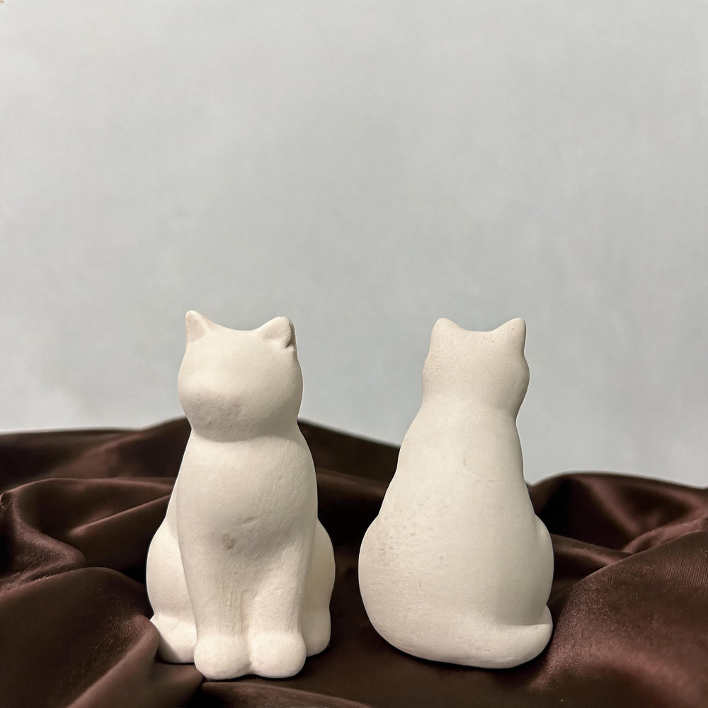 Unpainted head-tilt cat figurine – front and back
